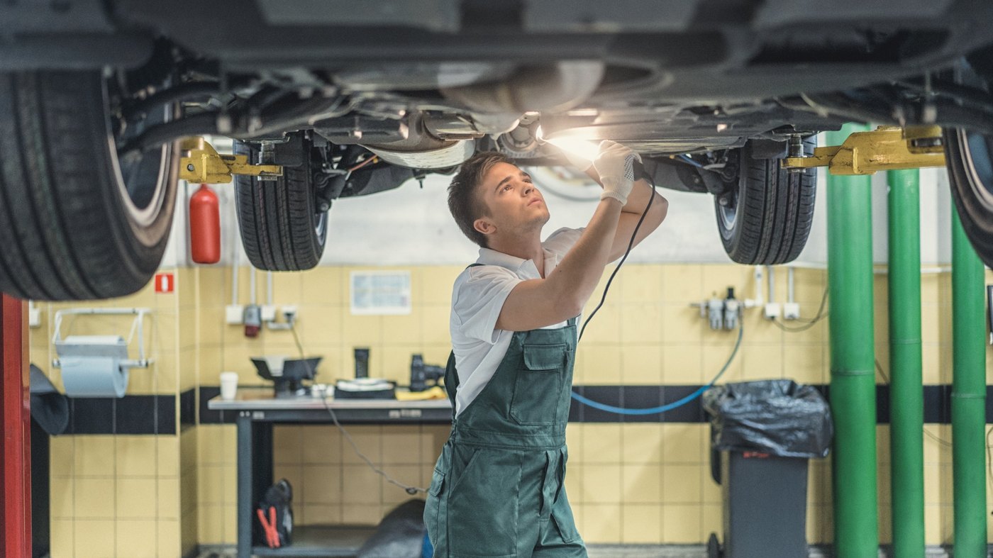 Mechanik naprawiający samochód na podnośniku